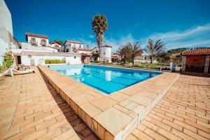 a swimming pool in front of a house at Pousada Montanhas do Sol in São Lourenço