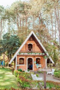 mały drewniany dom na dziedzińcu z drzewami w obiekcie Pousada Montanhas do Sol w mieście São Lourenço