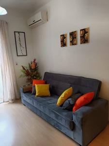 uma sala de estar com um sofá azul com almofadas coloridas em Apart hotel Centro Porto Alegre em Porto Alegre