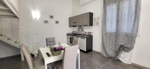a white kitchen with a table and a stove top oven at Monolocale Love Loft in Tropea