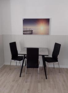 une table avec deux chaises et une photo d'une jetée dans l'établissement Kleines gemütliches Apartment in zentraler Lage, à Prien am Chiemsee