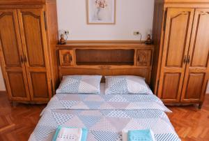 een slaapkamer met een bed met een houten hoofdeinde bij Jure Bili in Zadar