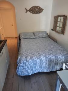 a bedroom with a bed with a blue comforter at Appartamento Blu in Deiva Marina