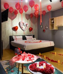 a bedroom with red balloons and a bed with a table at MT Apartments Skopje in Skopje