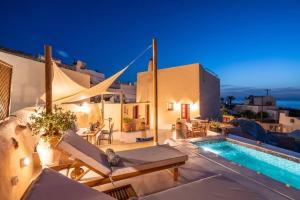 a villa with a swimming pool at night at Casa Terra Vedema Oia - Privacy - Plunge Pool & Panoramic Sunset Terrace in Oia