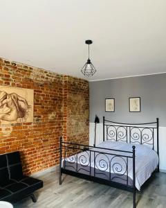 ein Schlafzimmer mit einem Bett und einer Ziegelwand in der Unterkunft Apartamenty ToTuGdynia 6 in Gdynia