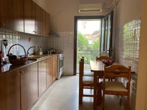 a kitchen with wooden cabinets and a table and a window at Family house near Lefkada in Vonitsa