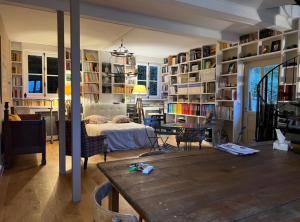 a living room with a bed and a table in it at L'Atelier du Paysagiste - maison d'artiste in Giverny