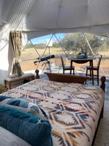 a bedroom with a tent with a bed and a table at Star Garden Az in Valle