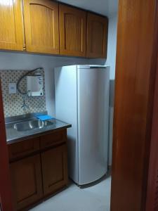 a kitchen with a white refrigerator and a sink at Apart hotel Centro Porto Alegre in Porto Alegre