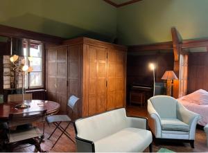 ジヴェルニーにあるL'Atelier du Paysagiste - maison d'artisteのベッドルーム1室(ベッド1台、テーブル、椅子付)