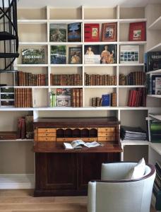 une étagère avec un bureau dans une bibliothèque dans l'établissement L'Atelier du Paysagiste - maison d'artiste, à Giverny