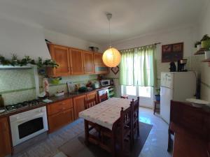 a kitchen with a table and a white refrigerator at Casa da Tina Conforto Familiar no Sítio da Nazaré in Nazaré