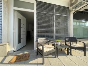 patio z 2 krzesłami, stołem i oknem w obiekcie Oliver w Ankaranie