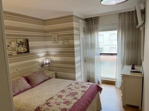 - une chambre dotée d'un lit avec un mur rayé dans l'établissement Apartamento ALBAMAR SANXENXO, à Sanxenxo