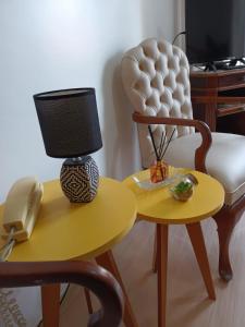 a chair and a table with a lamp and a phone at Apart hotel Centro Porto Alegre in Porto Alegre