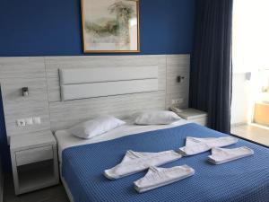 a bedroom with a bed with white towels on it at Blue Aegean Hotel & Suites in Gouves
