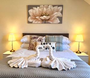 dos cisnes sentados en una cama en un dormitorio en Beautiful 3-bedroom house, city centre, parking, en Norwich