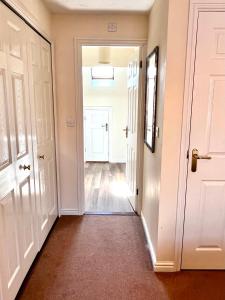um corredor vazio com uma porta branca e um hallwayngth em Beautiful 3-bedroom house, city centre, parking em Norwich
