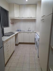 a white kitchen with a sink and a dishwasher at Stella Maris 194 Amazimtoti Self Catering accommodation in Amanzimtoti