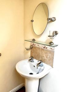 a bathroom with a sink and a mirror on the wall at Beautiful 3-bedroom house, city centre, parking in Norwich