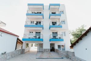 ein weißes Apartmenthaus mit blauen Balkonen in der Unterkunft BLUE AND WHITE LUXURY suites in Nea Kallikratia