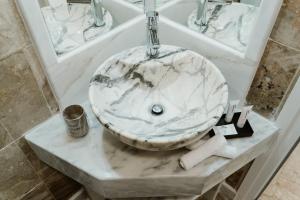 a bathroom with a marble sink on a counter at BLUE AND WHITE LUXURY suites in Nea Kalikratia +41 photos