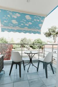 a balcony with a table and two chairs and a view at BLUE AND WHITE LUXURY suites in Nea Kalikratia