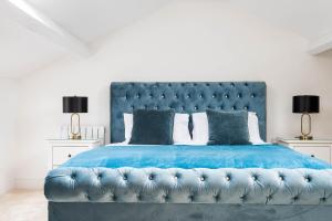 una camera con un letto blu con due lampade di Monterey Residence - Stunning, Duplex Apartment in the Heart of Kendal a Kendal