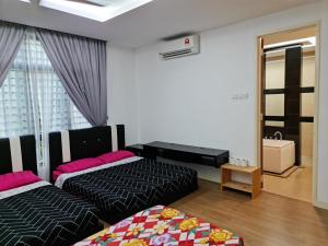 a hotel room with two beds and a mirror at Pearl Residences Sleep 27 in Batu Ferringhi