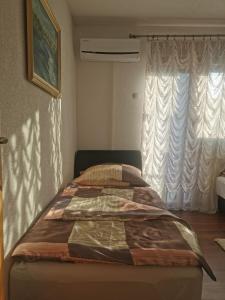 a bed sitting in a room with a window at House Leyla in Bihać