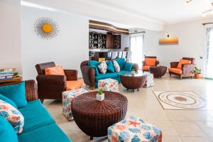 a living room with couches and chairs and a table at Dilina Studios in Arkasa