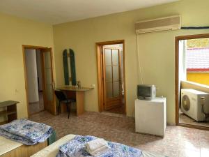 a room with two beds and a tv and a table at Vila George in Eforie Sud