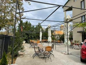 a patio with chairs and a table with umbrellas at Vila George in Eforie Sud