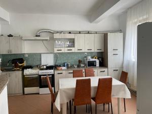 a kitchen with a table with chairs and a stove at Vila George in Eforie Sud