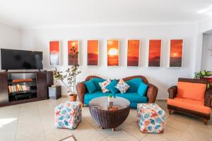 uma sala de estar com um sofá azul e duas cadeiras em Dilina Studios em Arkasa