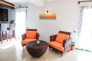 a living room with two chairs and a table at Dilina Studios in Arkasa