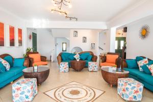 a living room with blue couches and orange chairs at Dilina Studios in Arkasa