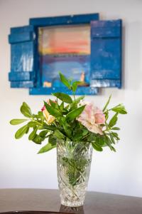 a vase with flowers in it sitting on a table at Dilina Studios in Arkasa
