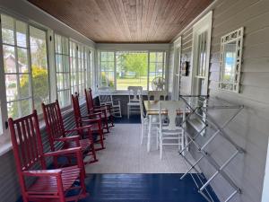 un porche cubierto con sillas y mesa en Drop Anchor Cottages and Lake House en Geneva-on-the-Lake