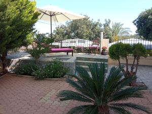 a patio with a pink bench and an umbrella at Kallia's Sea View Home Suite in Hersonissos