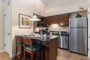 a kitchen with a stainless steel refrigerator and wooden cabinets at Chase Suite El Paso in El Paso