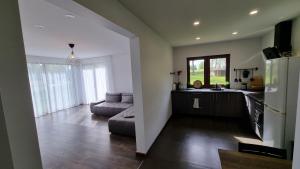 a large living room with a couch and a kitchen at Lauviņu rezidence in Kocēni