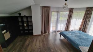 a bedroom with a bed and a large window at Lauviņu rezidence in Kocēni