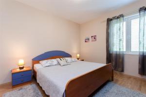 Un dormitorio con una cama grande y una ventana. en Apartments Marotin, en Rab