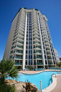 a large building with a swimming pool in front of it at Jade East Condominiums in Destin