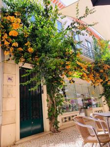 un albero con fiori d'arancio davanti a una porta di Senhor Gigi a Faro