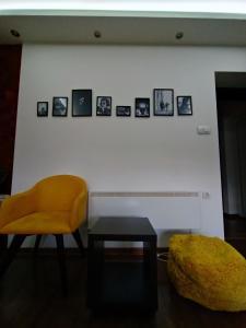 a room with a chair and a table and pictures on the wall at Leon in Gornji Milanovac