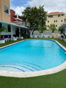 a large blue swimming pool in front of a building at Ramada by Wyndham Princess Santo Domingo in Santo Domingo