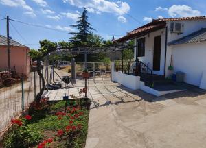 a house with a fence and a yard with flowers at Stella House in Theológos